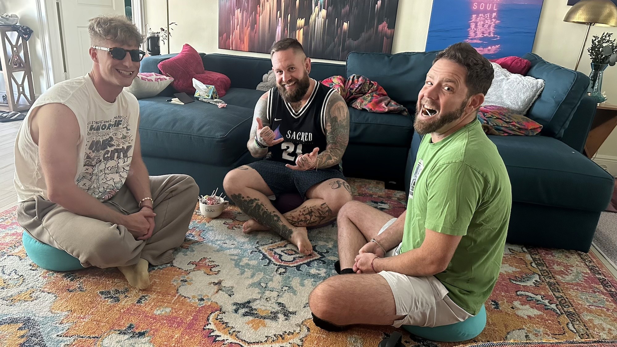 Three men sitting together in a circle, laughing